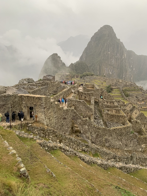 Machu Picchu ruins with tourists exploring.