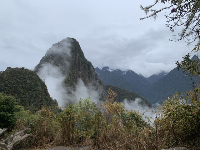       Cloud-covered mountains with lush greenery.
  