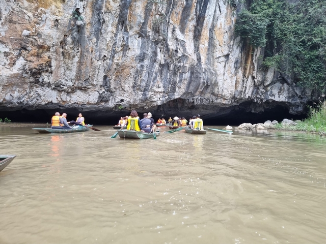 Tourists rowing boats into a cave.