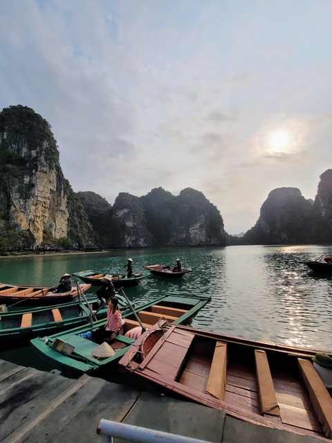 Boats on the water against a backdrop of limestone cliffs.