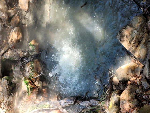       Water flowing over rocks in a natural setting.
  