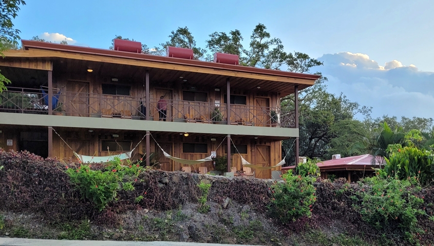 A wooden building with balconies and hammocks.