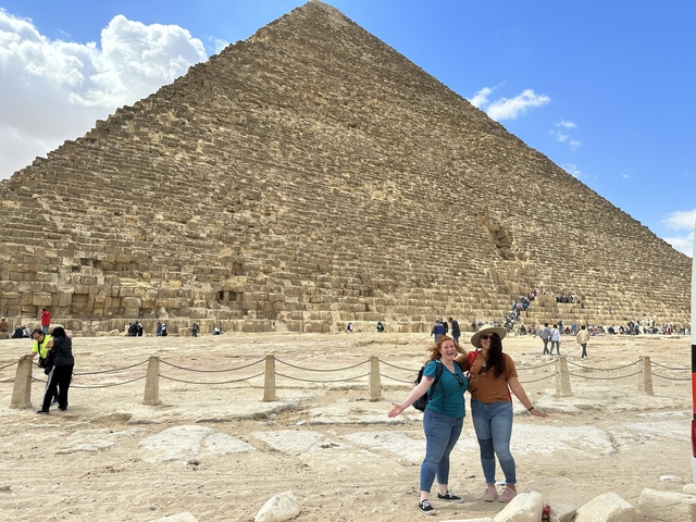 Two women posing in front of the Great Pyramid of Giza.