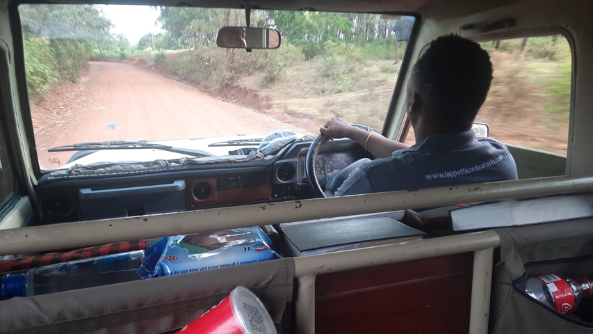 A person driving a vehicle on a dirt road.