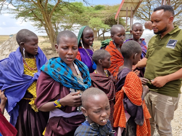 A group of people interacting, wearing colorful traditional clothing.