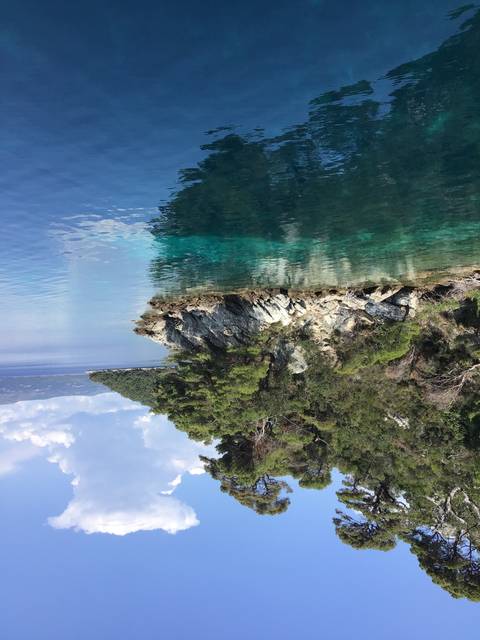 Coastal scene with clear blue water and rocky shorelines.