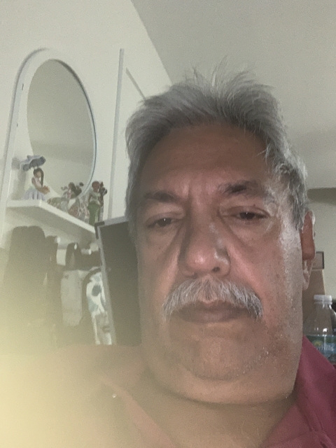       Close-up of a man's face with shelves in the background.
  