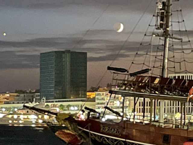       Blurred image of a boat and cityscape at night.
  