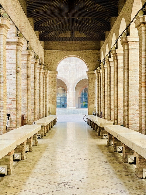       Historic brick arcade leading to a courtyard.
  
