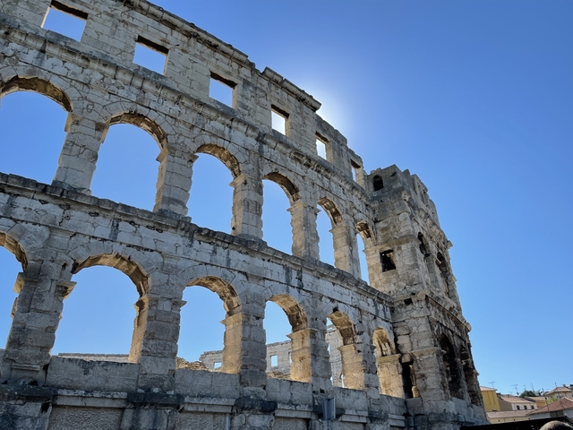       Ancient Roman amphitheater with blue sky.
  