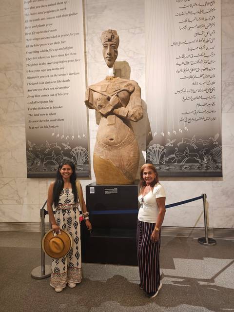       Two people standing beside an artifact in a museum.
  