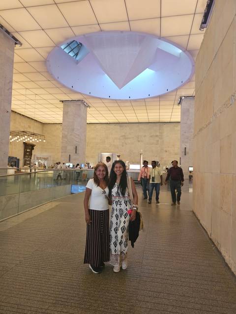       Two individuals inside a modern architecture building.
  