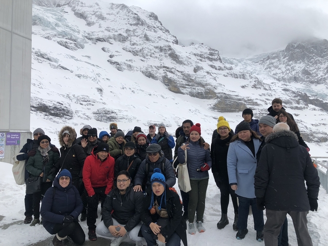       Group of people posing in snowy mountains.
  