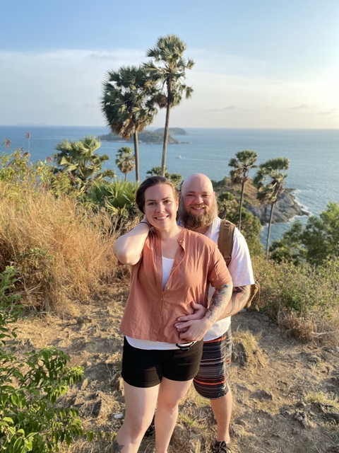       Couple posing in front of a scenic ocean view.
  