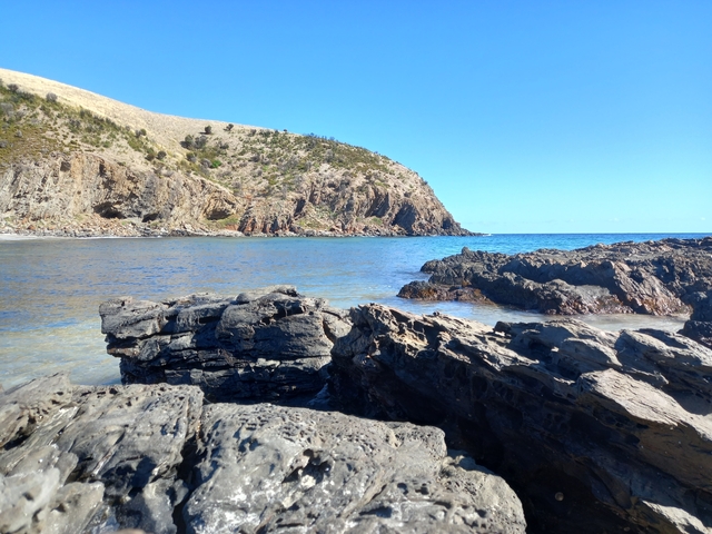 Rocky coastline with clear blue water and sunny sky.