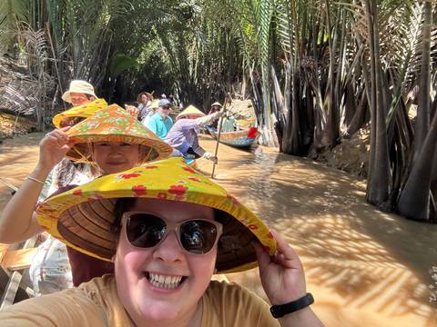       Tourists in a boat navigating through a tropical setting.
  