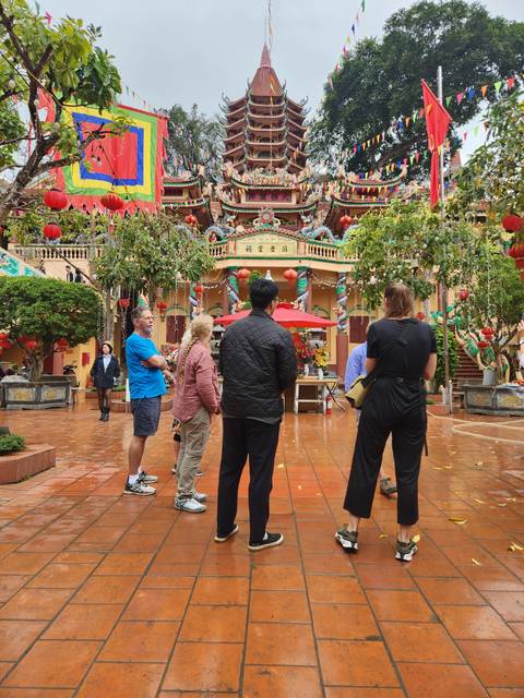       People exploring a colorful shrine with intricate decorations.
  