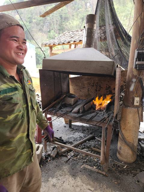       Person standing near a furnace with flames.
  