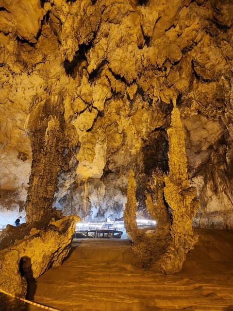       Stalagmites in a cave with artificial lighting.
  