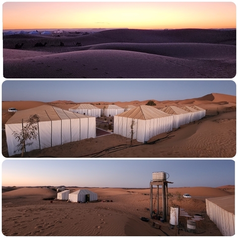 Desert camp with tents set up in a row.