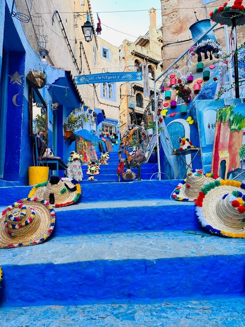 Colorful street scene in Chefchaouen with traditional items.