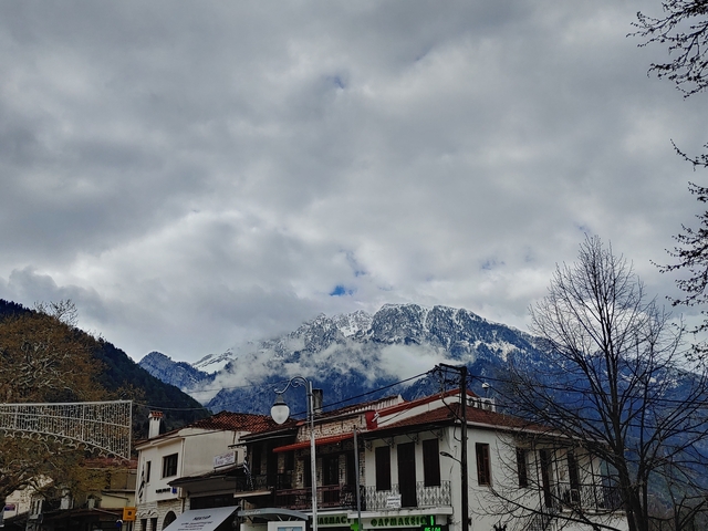       Snow-capped mountains partially obscured by clouds.
  