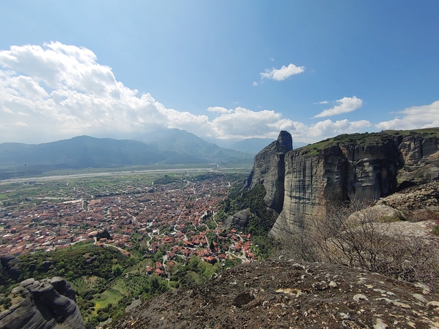       Aerial view of Meteora rock formations with a village below.
  