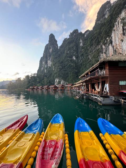 Colorful kayaks and wooden structures near a lake.
