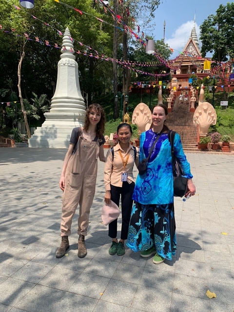 Three women posing in front of temple-like architecture.