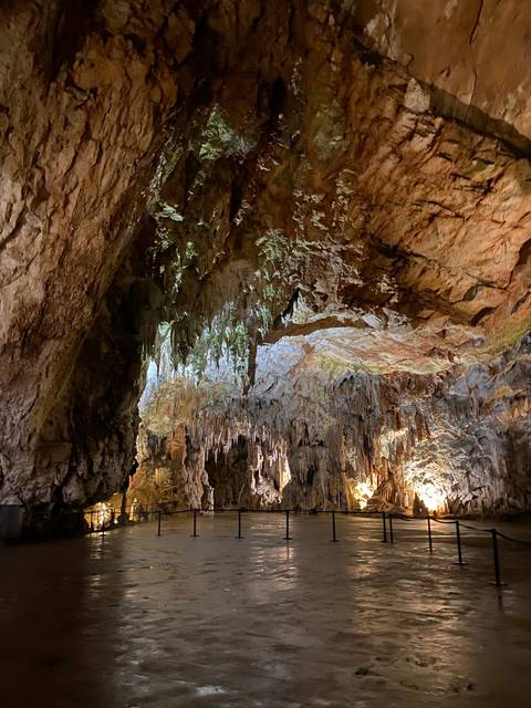 A spectacular cave interior with stalactites and lighting.