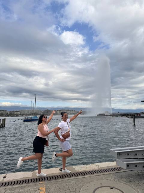 Two people posing near a waterfront.
