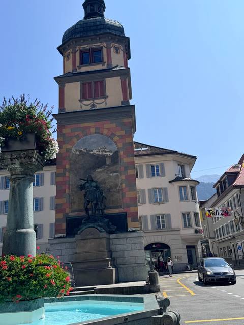       Historic tower and building with a fountain.
  