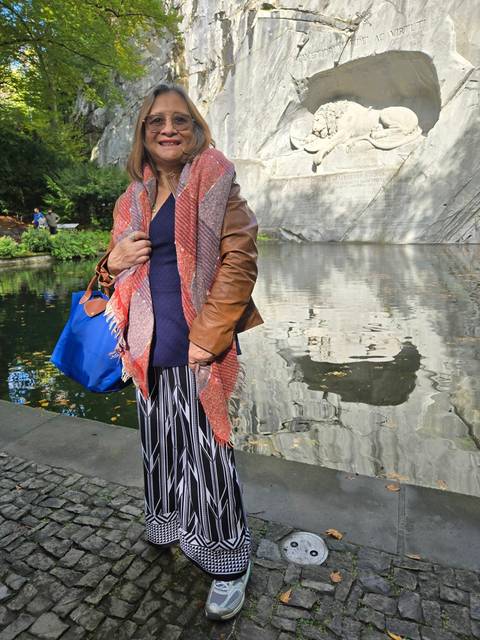 Person standing in front of a large stone carving.