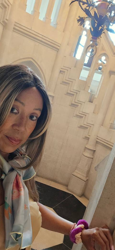       Person taking a selfie indoors with architectural background.
  