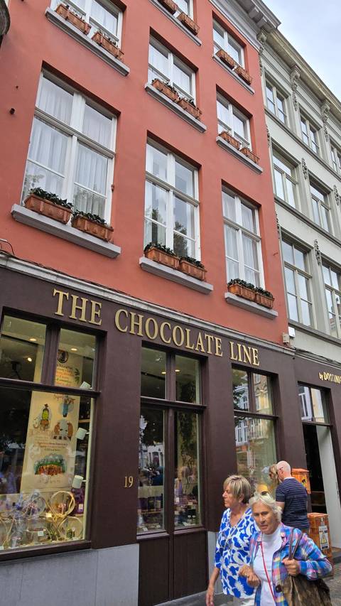       Shopfront with people passing by.
  