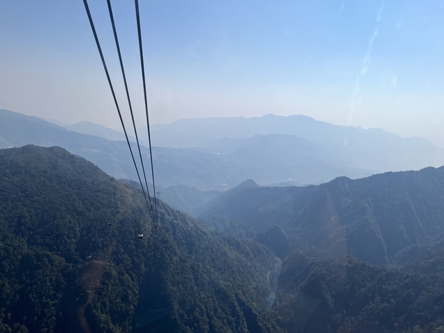 Scenic view of mountains with cable cars against a blue sky.