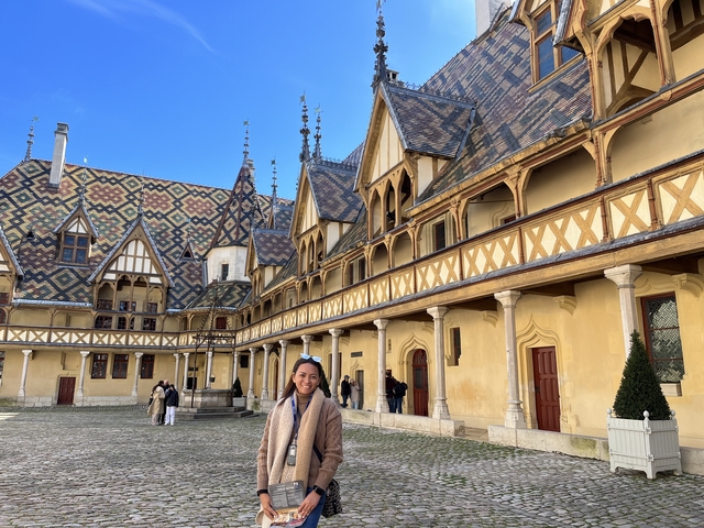 Person standing in front of a historical building with decorative tiles.