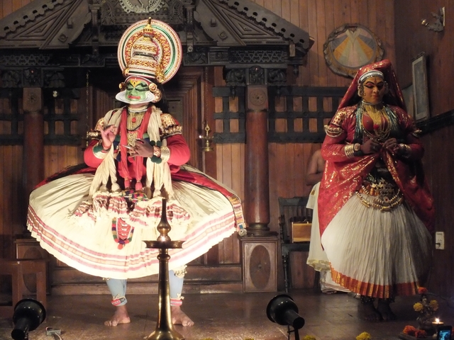 Two performers in traditional attire on stage.