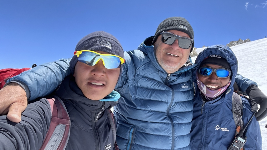       Three people in cold weather gear posing in a snowy landscape.
  