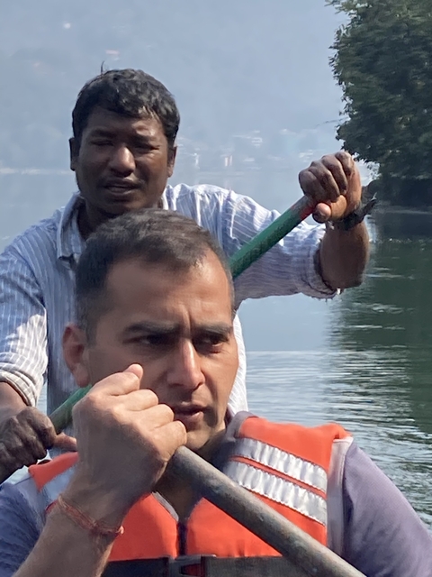       Close-up of two people paddling a boat.
  