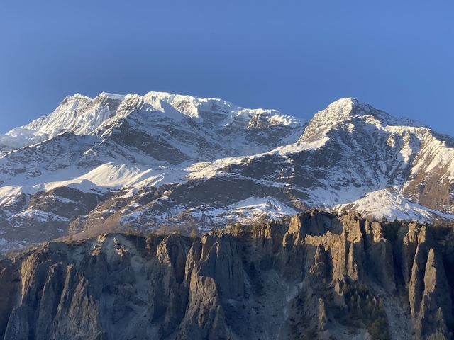       Snow-capped mountains under a clear blue sky.
  