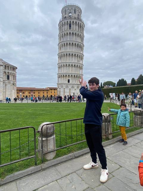 Person posing tilted sideways with the Leaning Tower of Pisa.