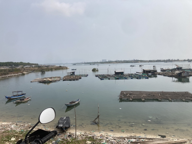       View of a harbor with small boats and rafts.
  