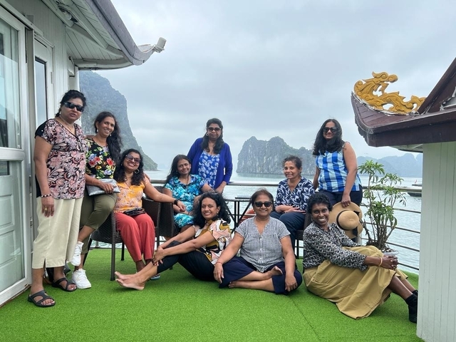 Group of women posing on a deck with limestone mountains in the background