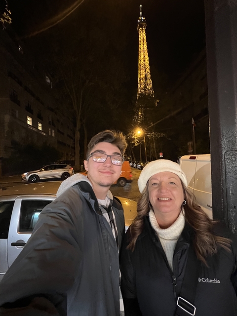Two people taking a selfie at night with city lights