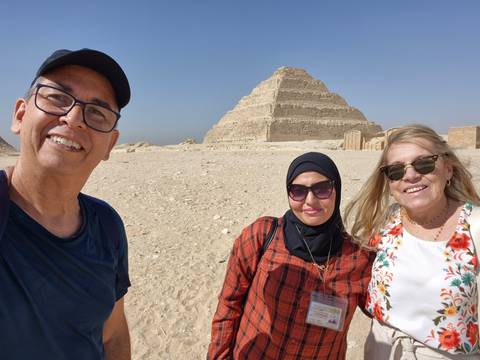 Group of people with a pyramid in the background.