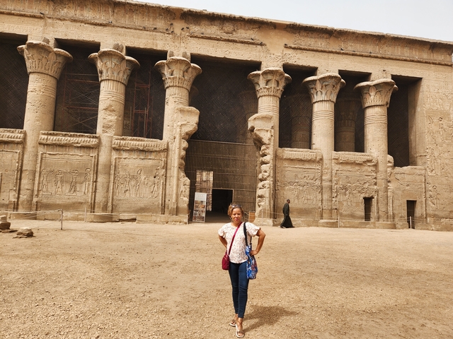 Person posing in front of a historical monument.