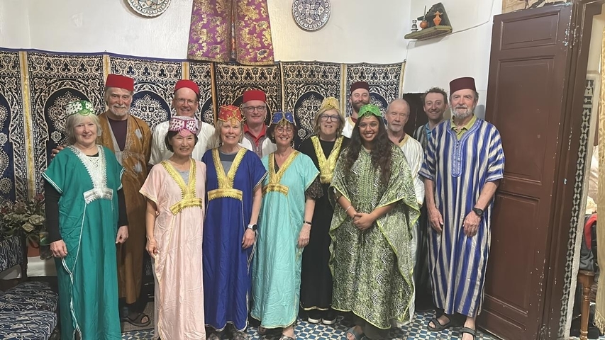 Group of people dressed in traditional Moroccan clothing indoors.