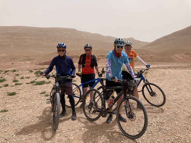       Group of cyclists in a rocky landscape.
  