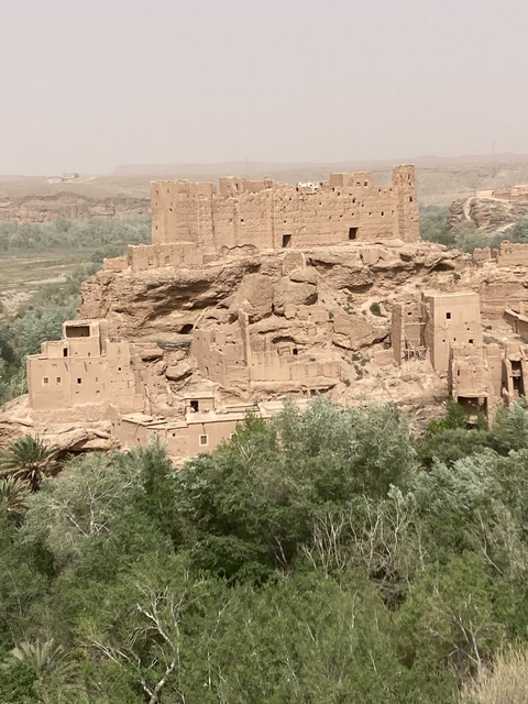       Ancient clay buildings built into a hillside.
  